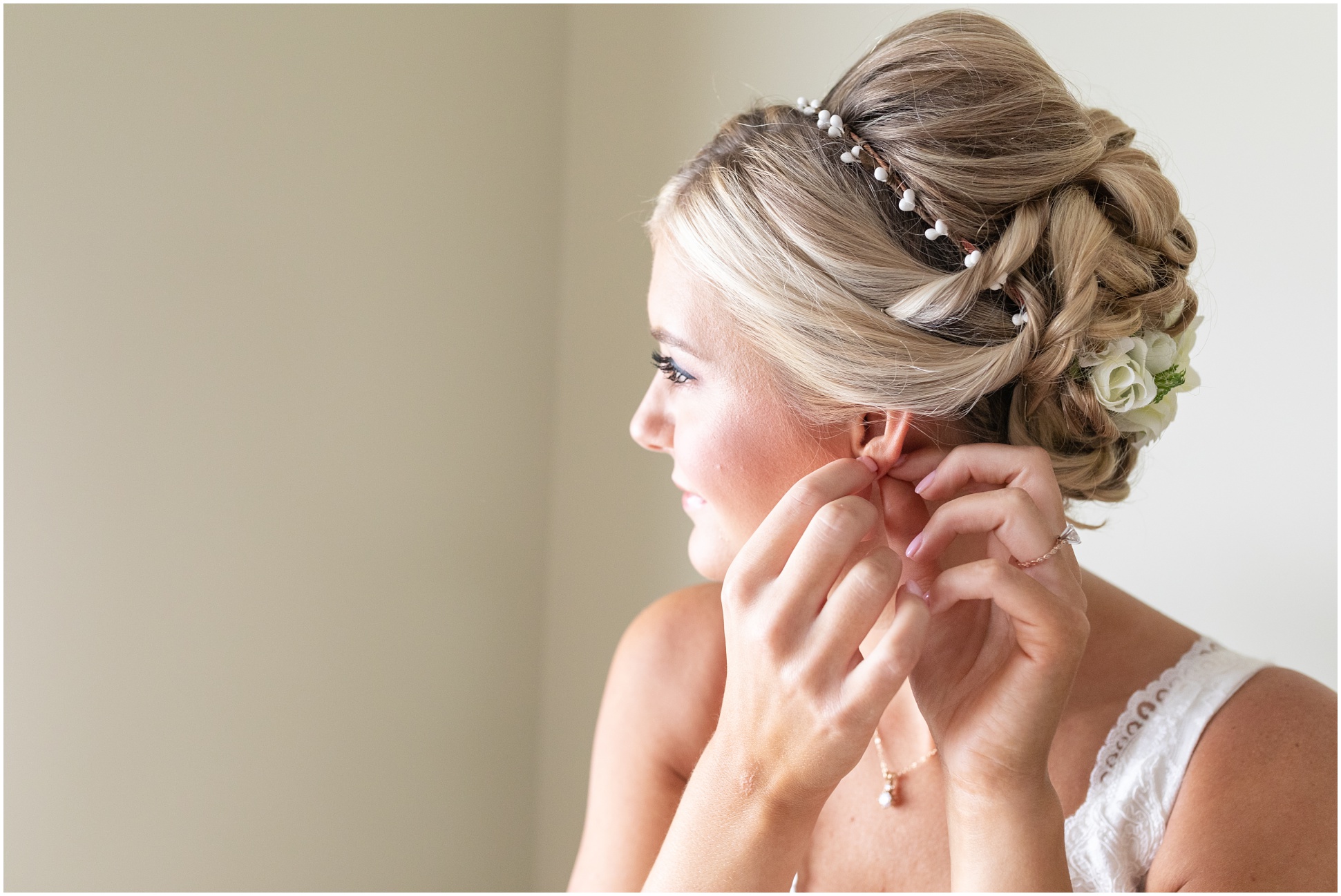 A close up shot of bride putting on her earring.
