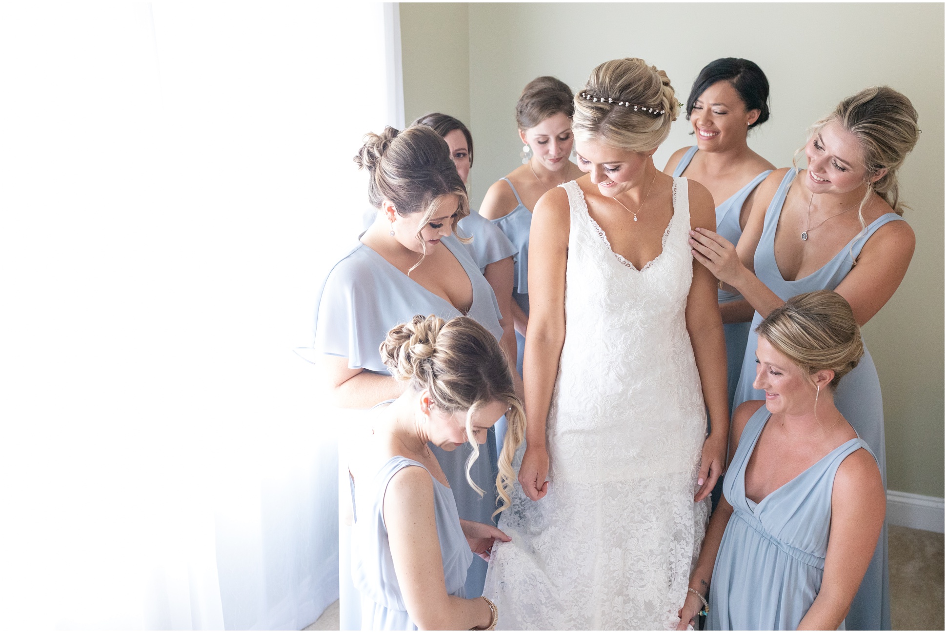 Bridesmaids helping bride with dress