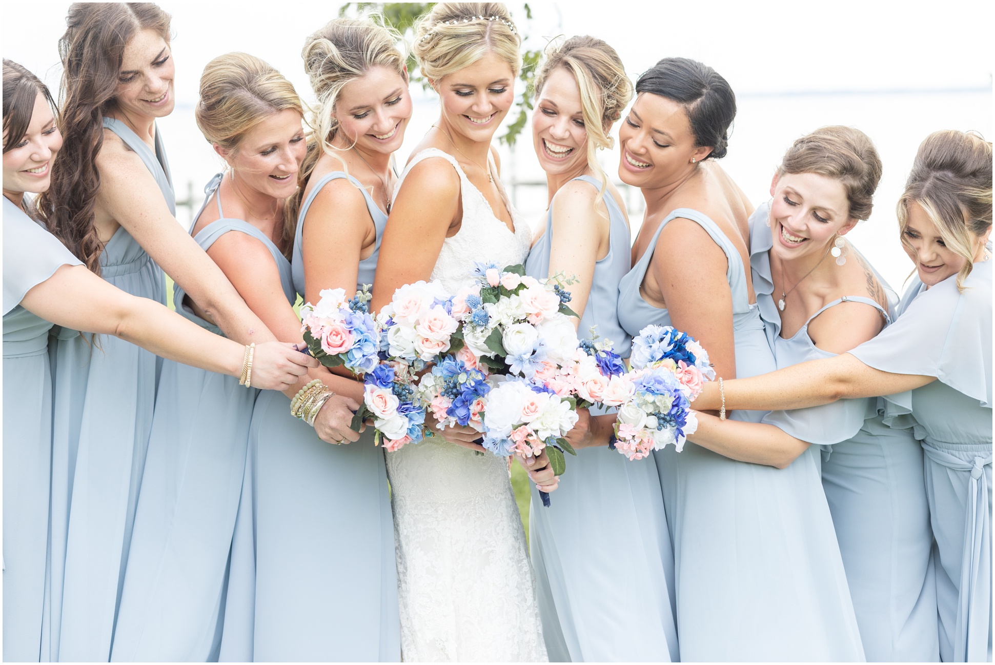 Bridesmaids standing around the bride with their beautiful handmade bouquets