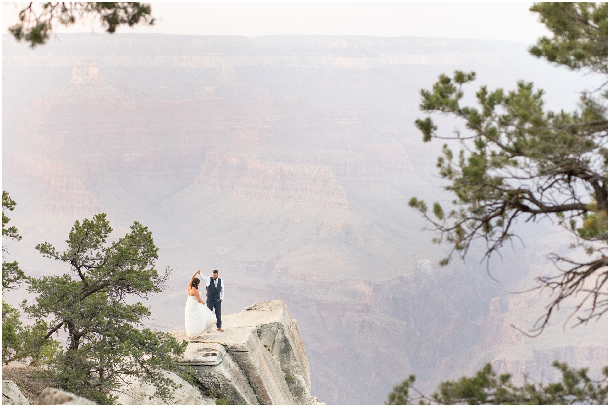 Groom twirling his bride out on the rock of the Southern Rim of the Grand Canyon