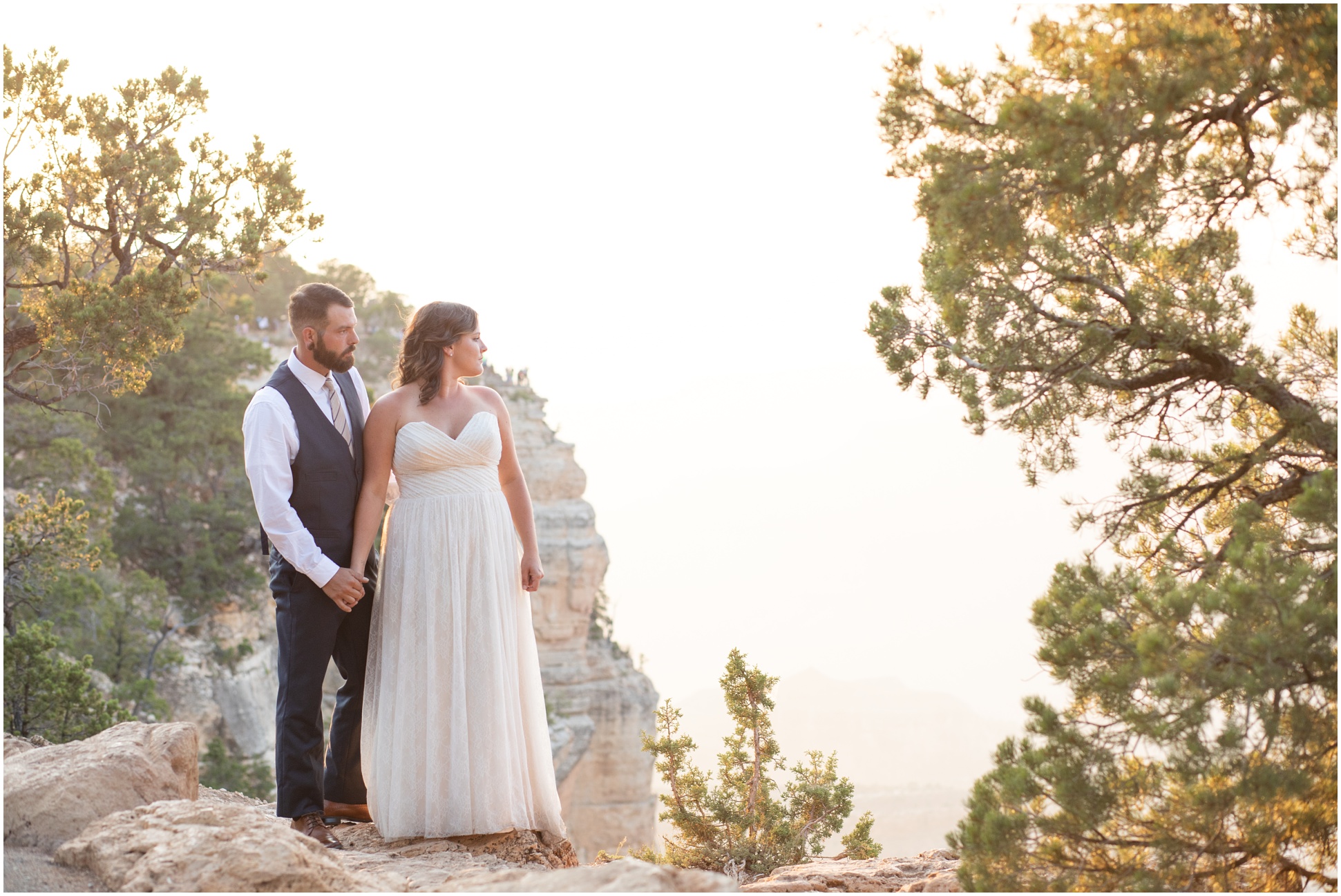 Bride and groom looking out over the south rim of the grand canyon at sunset