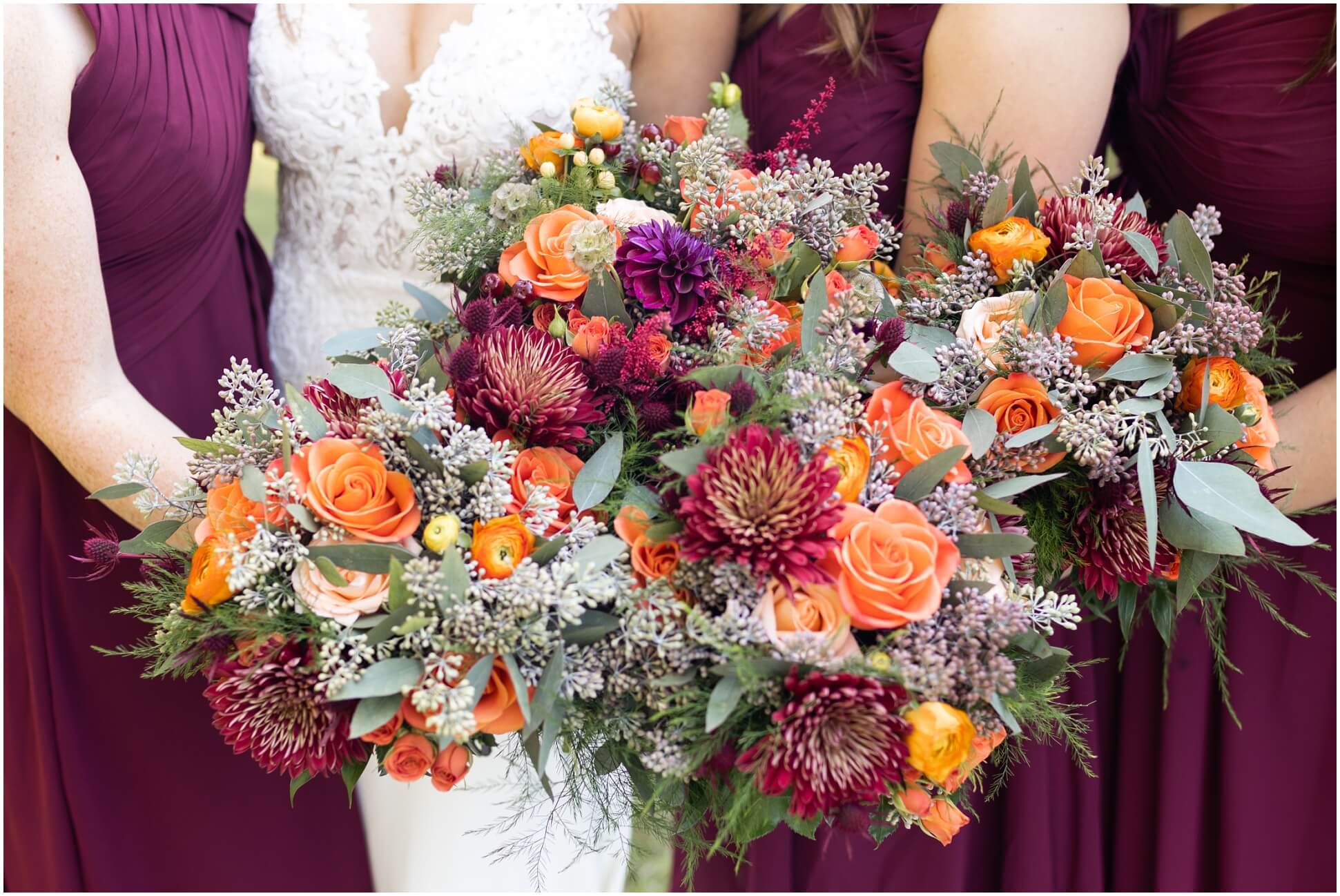 BURGUNDY AND ORANGE FLOWERS IN BOUQUETS WITH EUCALYPTUS GREENS