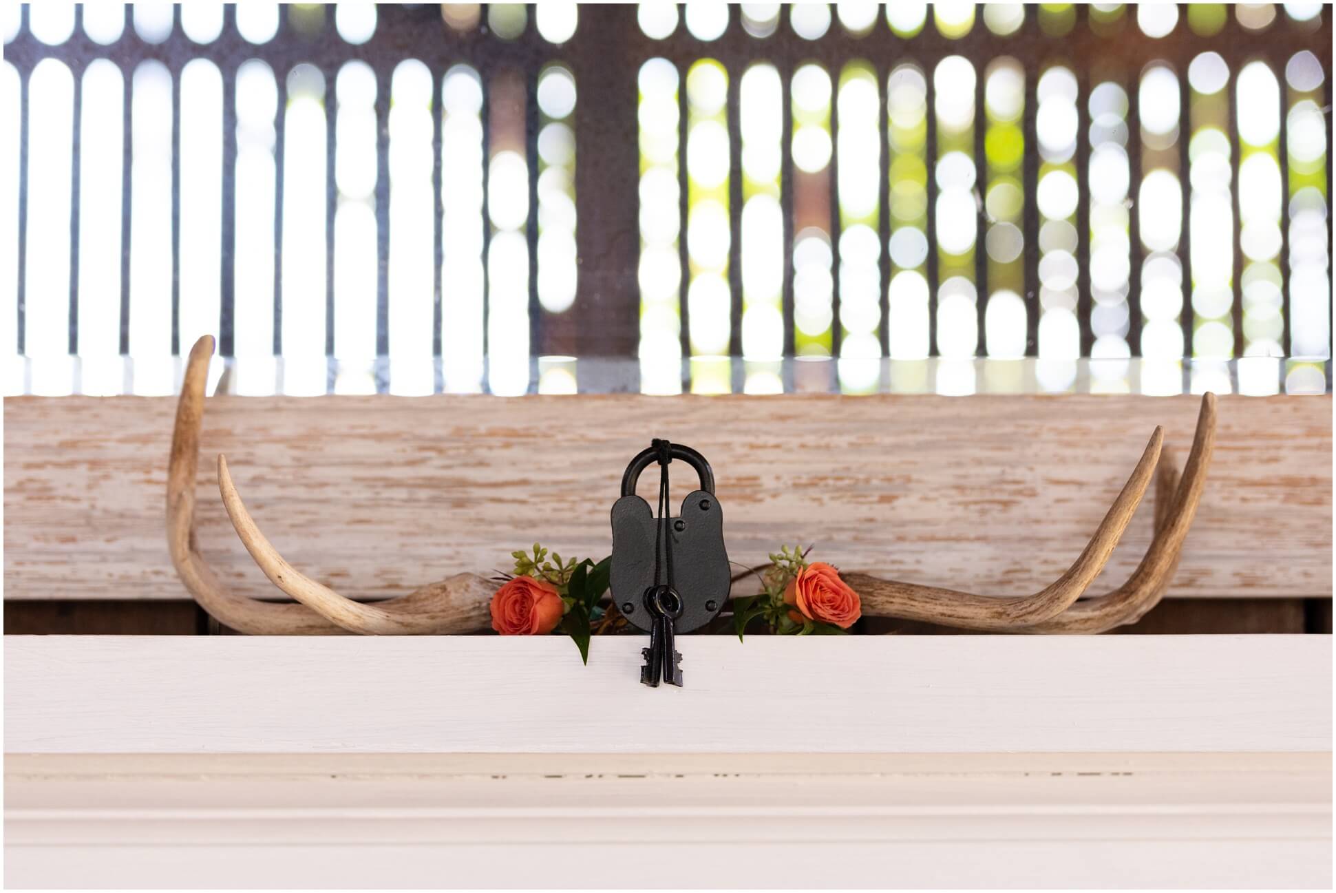 DEER ANTLERS, BOUTONNIERES, AND WEDDING LOCK ON THE MANTEL OF THE GROOM'S SUITE AT WINDING CREEK FARM, VIRGINIA