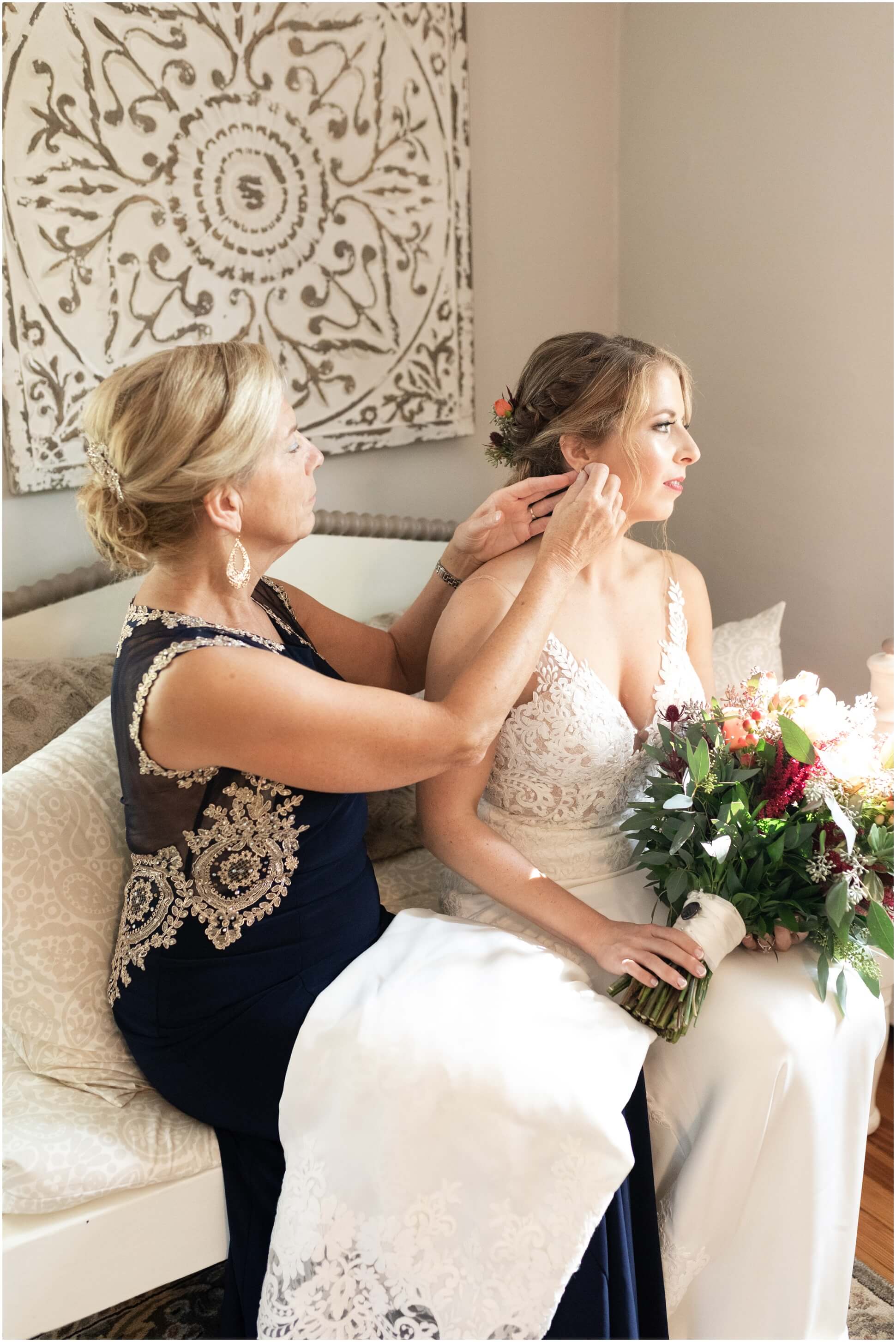 BRIDE'S MOM FIXING BRIDE'S EARRINGS BY THE WINDOW