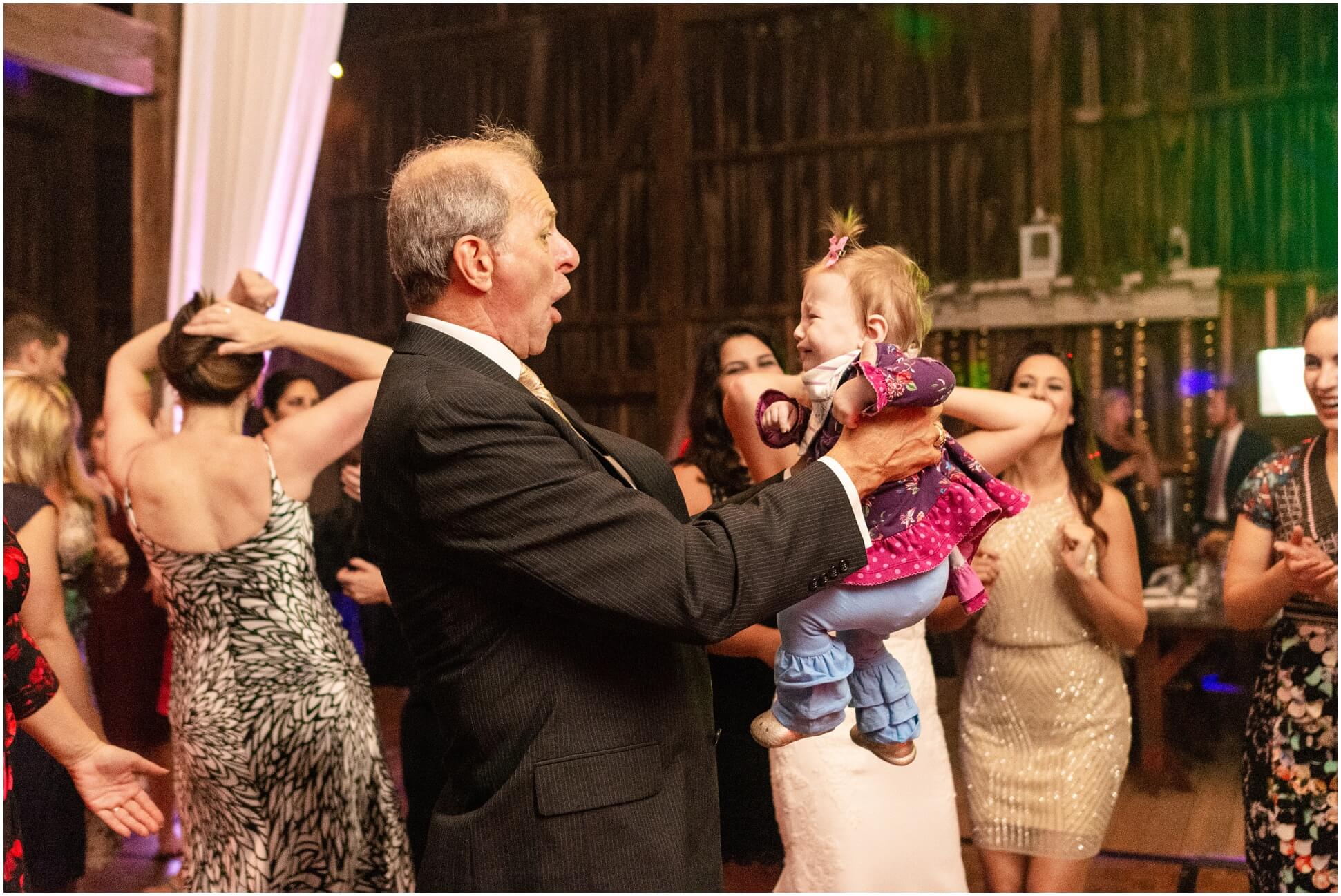 FATHER OF THE BRIDE DANCING WITH A CRING BABY