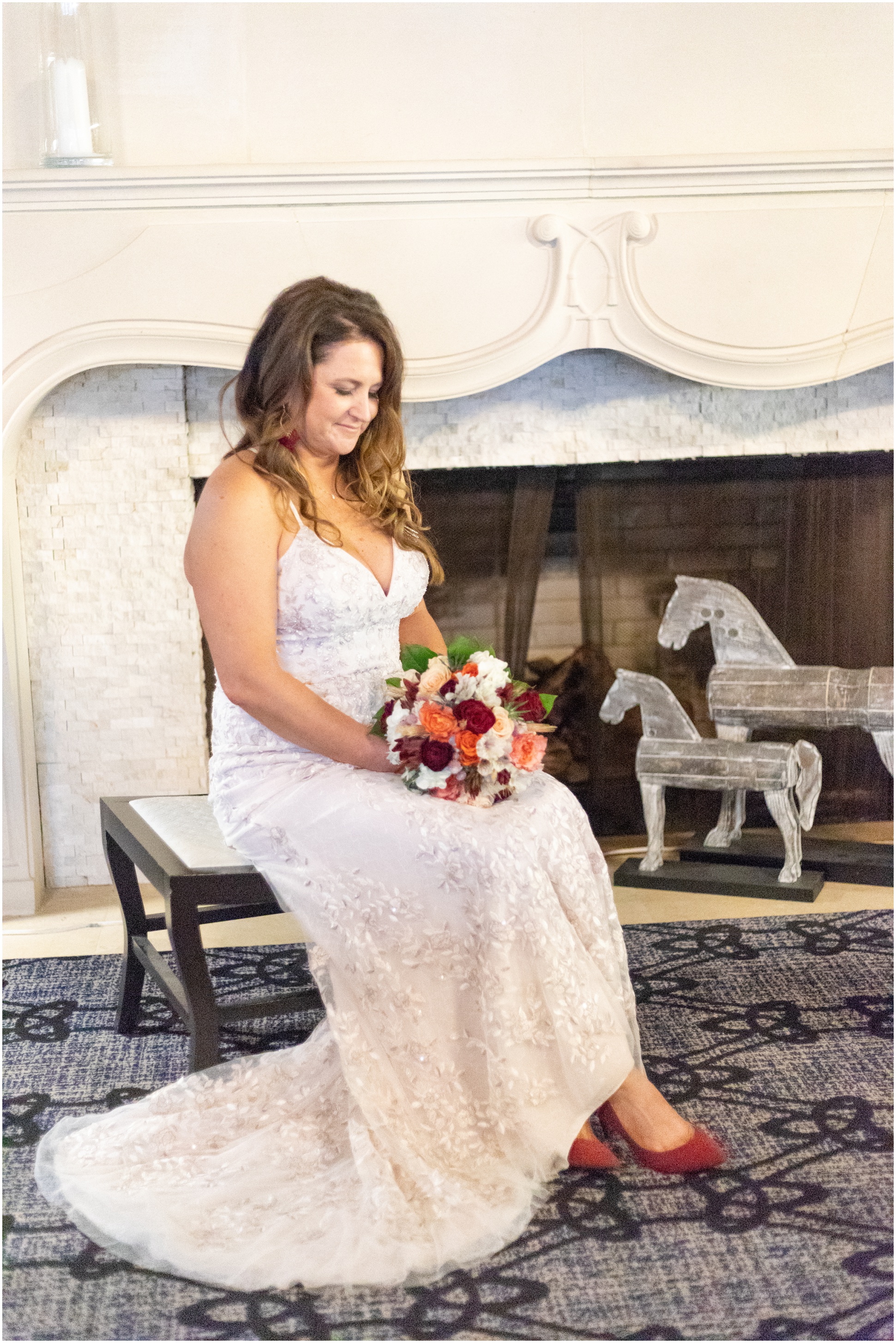 Bride sitting in front of fire place at Delta Hotel with bouquet in lap