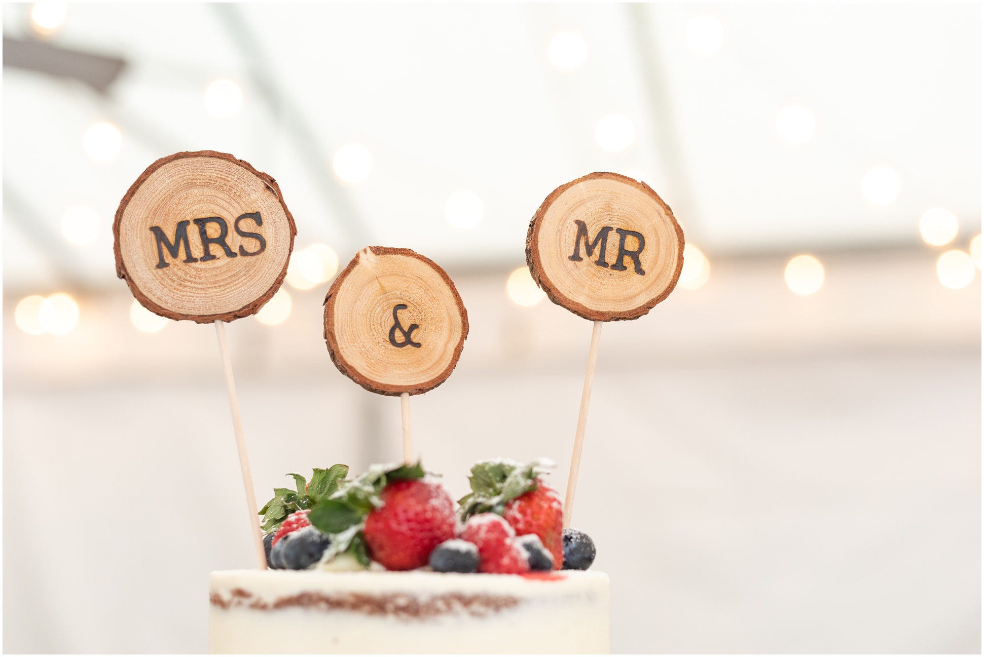 Mr and Mrs Cake Toppers ontop of cake with fresh straweberries and blueberries