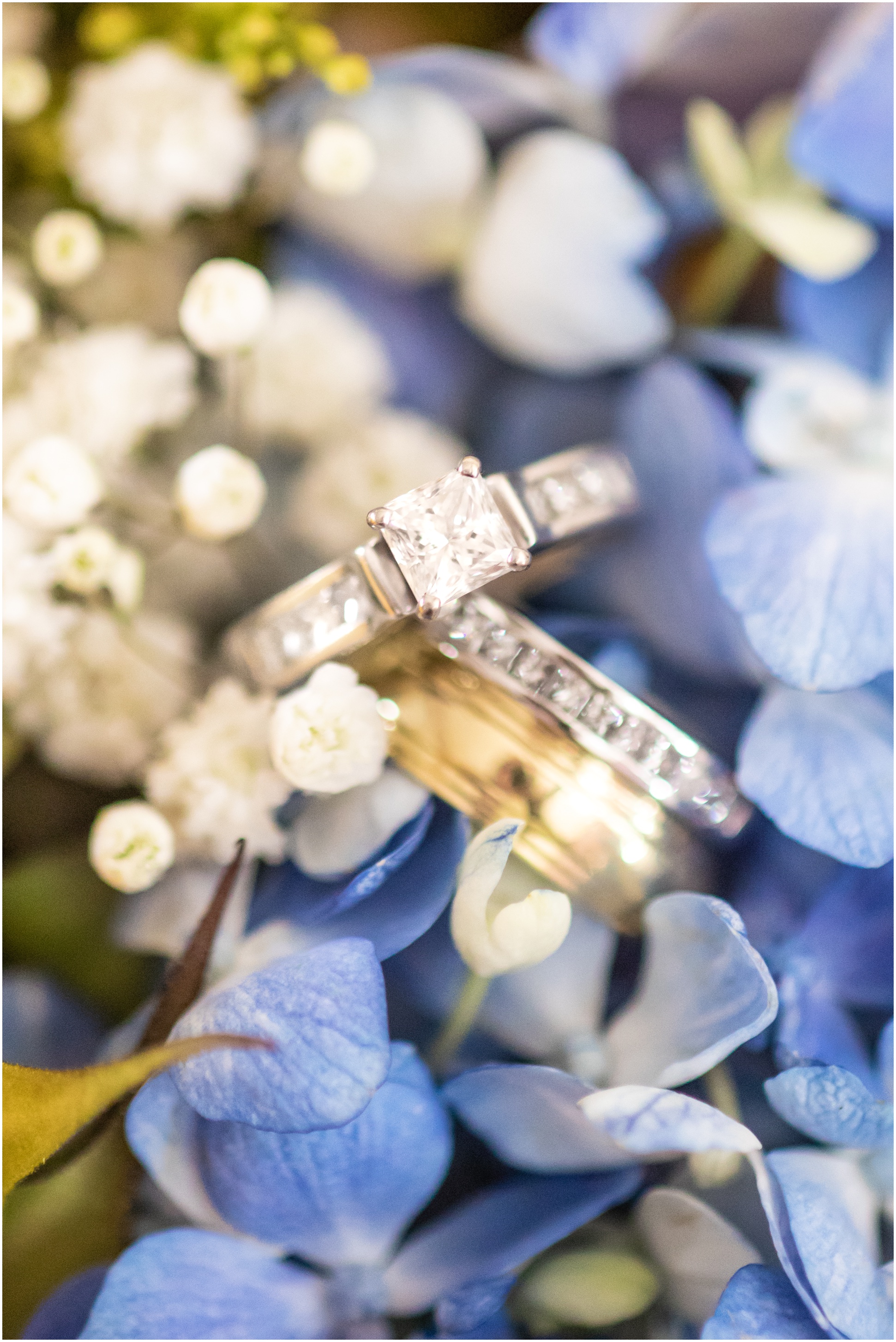 Wedding Rings in the bouquet of sunflowers, baby's breath, and blue hydrangas