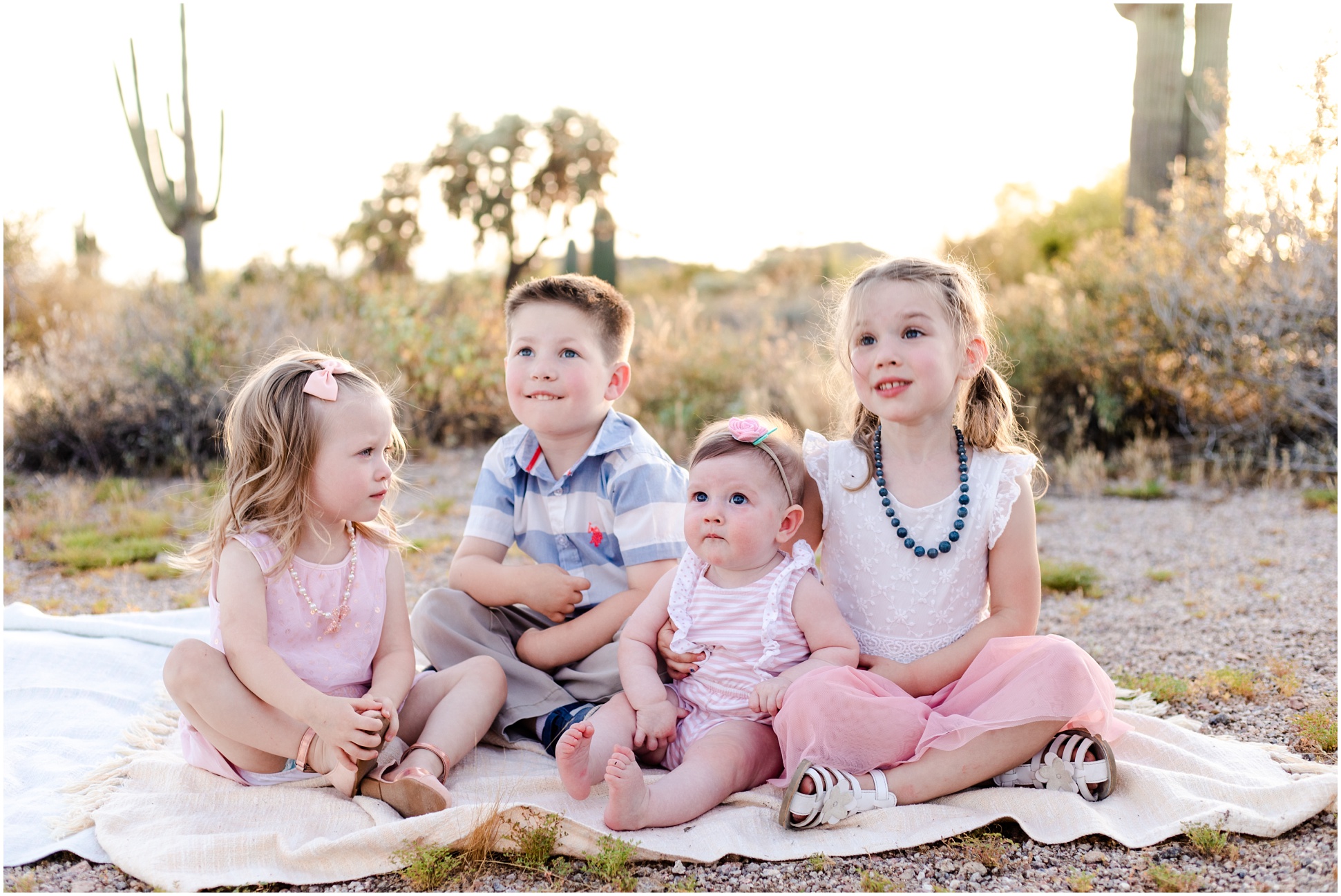 All the grandkids sitting together on a blanket