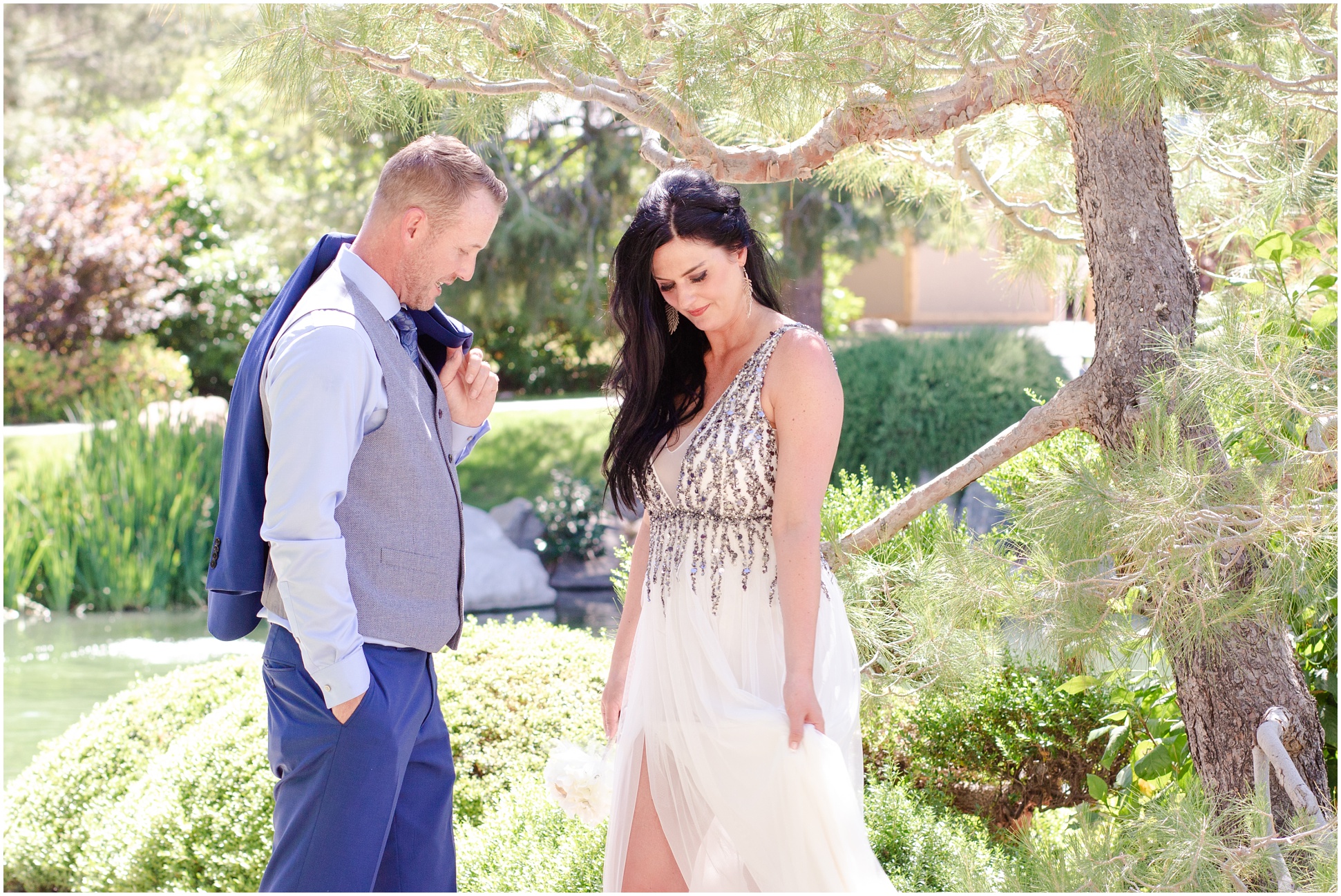 Groom wearing gray vest and blue suite. Bride wearing sequenced white chiffon dress with a slit