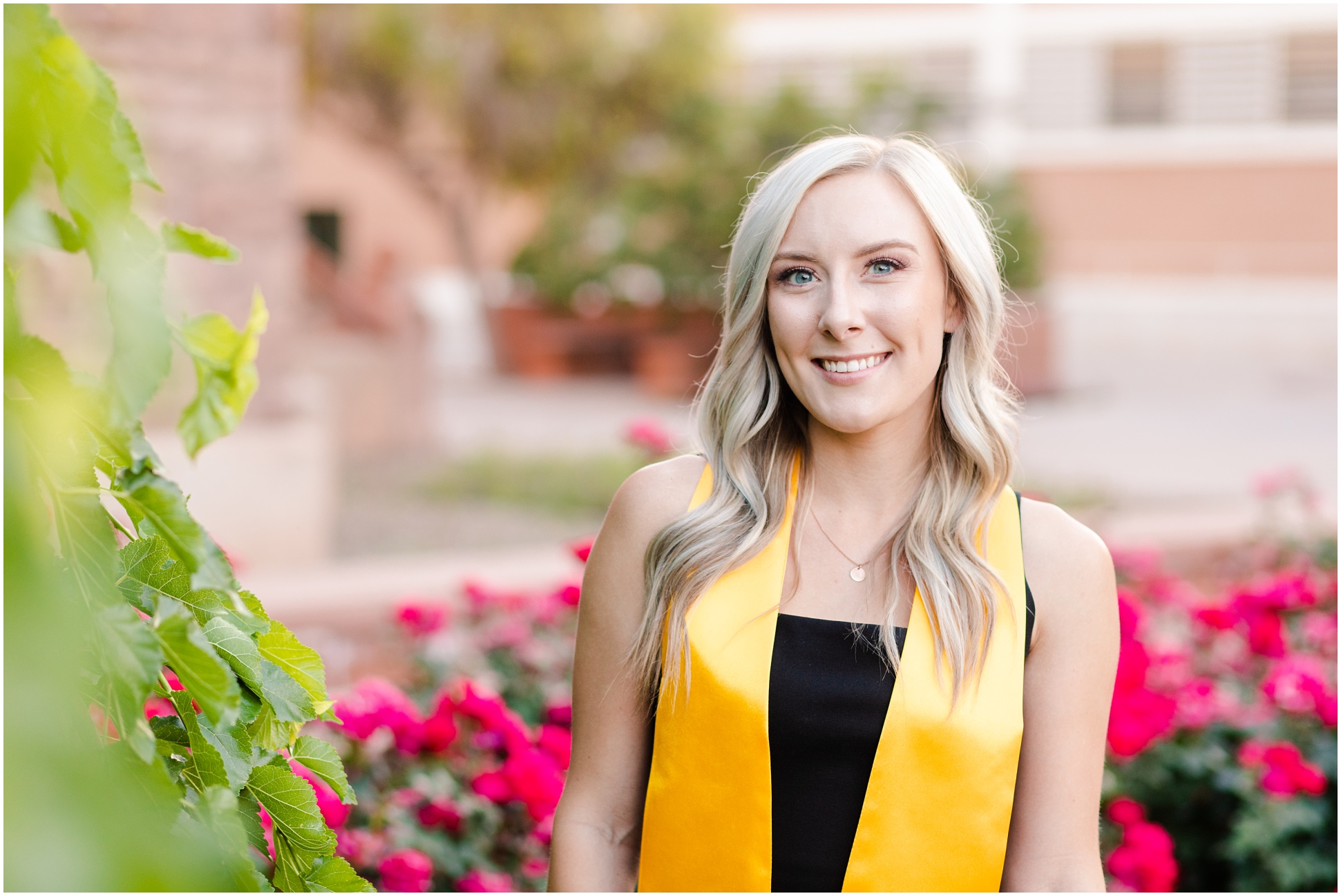 Kaitlyn Schares standing next to greenery wearing her stole at Old Main on ASU Campus
