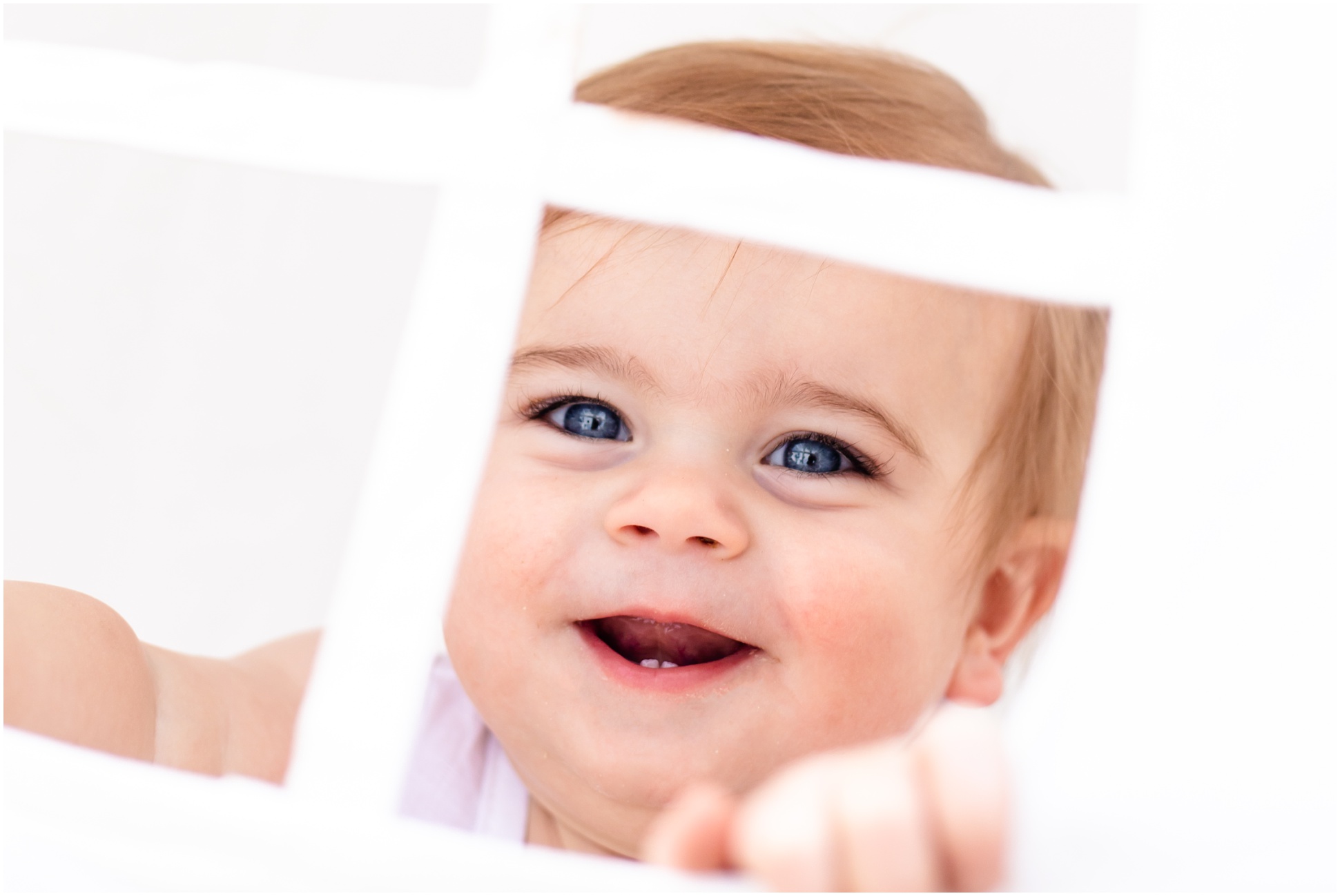 Karsyn looking through the window of his tent, laughing at his first birthday portraits