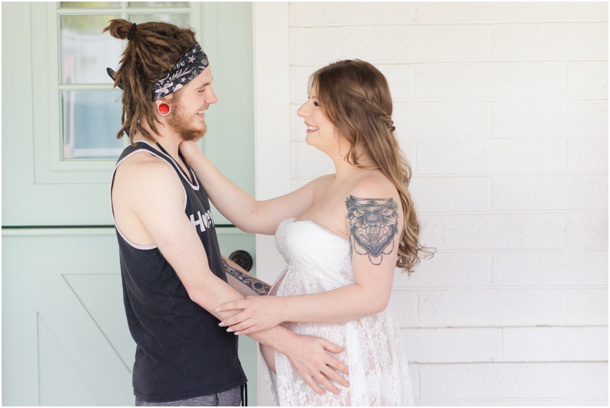Pregnant Woman wearing lace maternity dress embracing husband