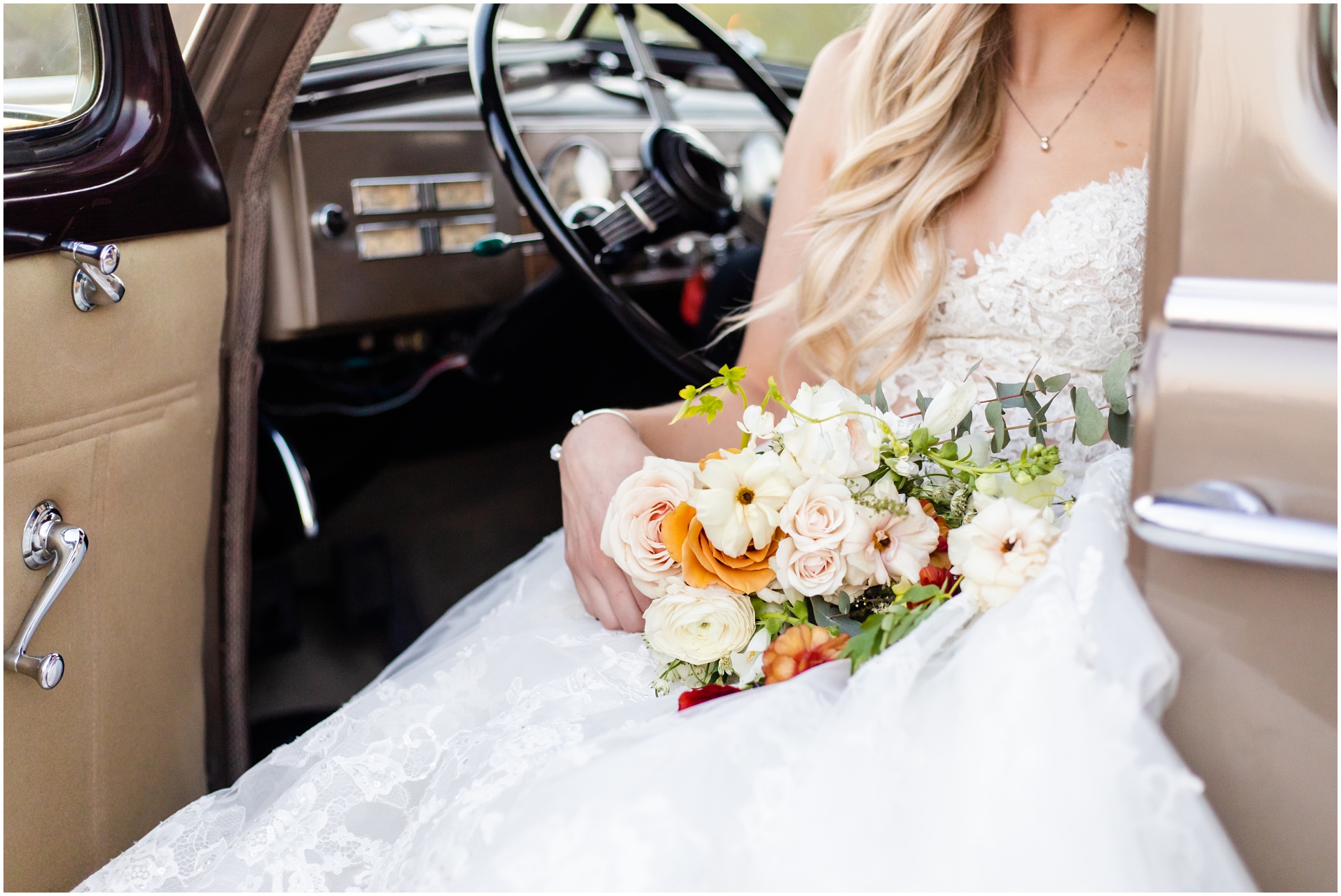 Brooklyn sitting in drivers seat in Enzoani Gown with door open and Wild Flower AZ flowers on lap