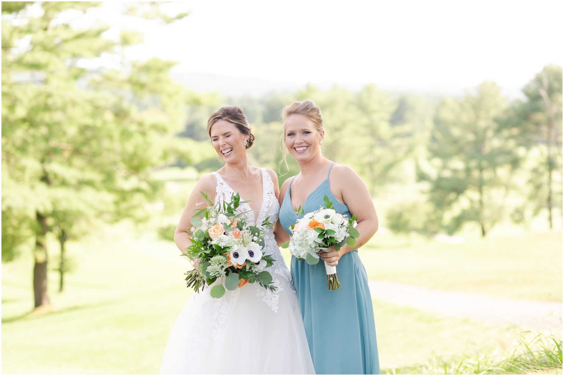 Bride and Maid of Honor Laughing. Maid of Honor wearing blue dress.