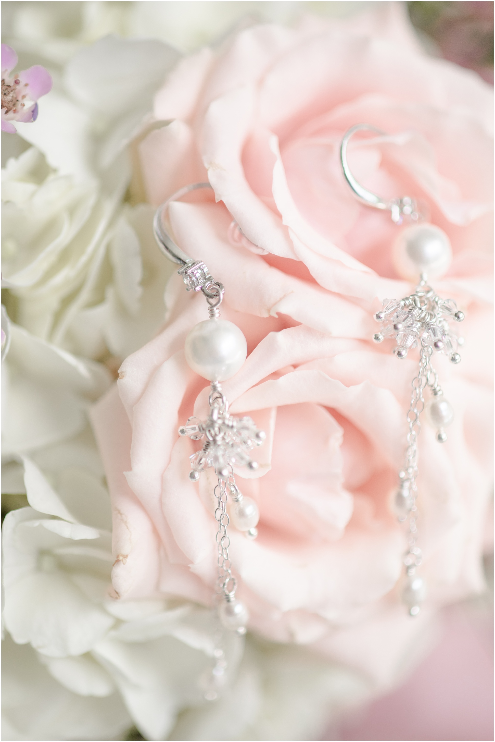Dangling earrings hanging from blush roses