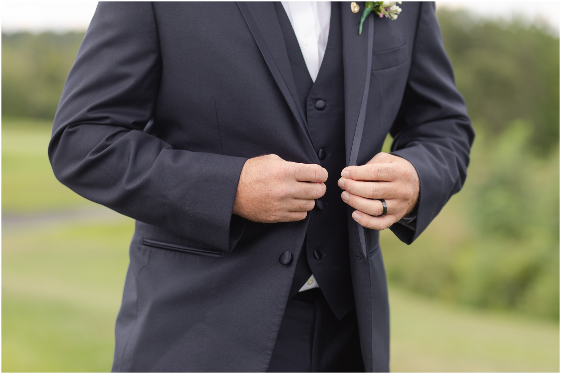 The groom buttoning up his jacket