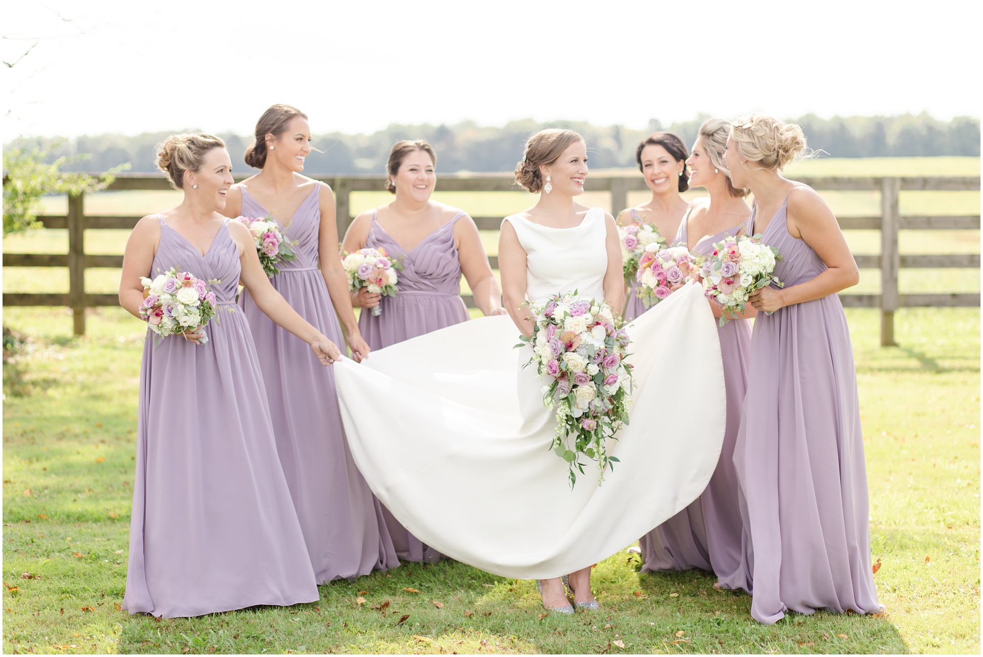 Bridesmaids holding up the bride's grown