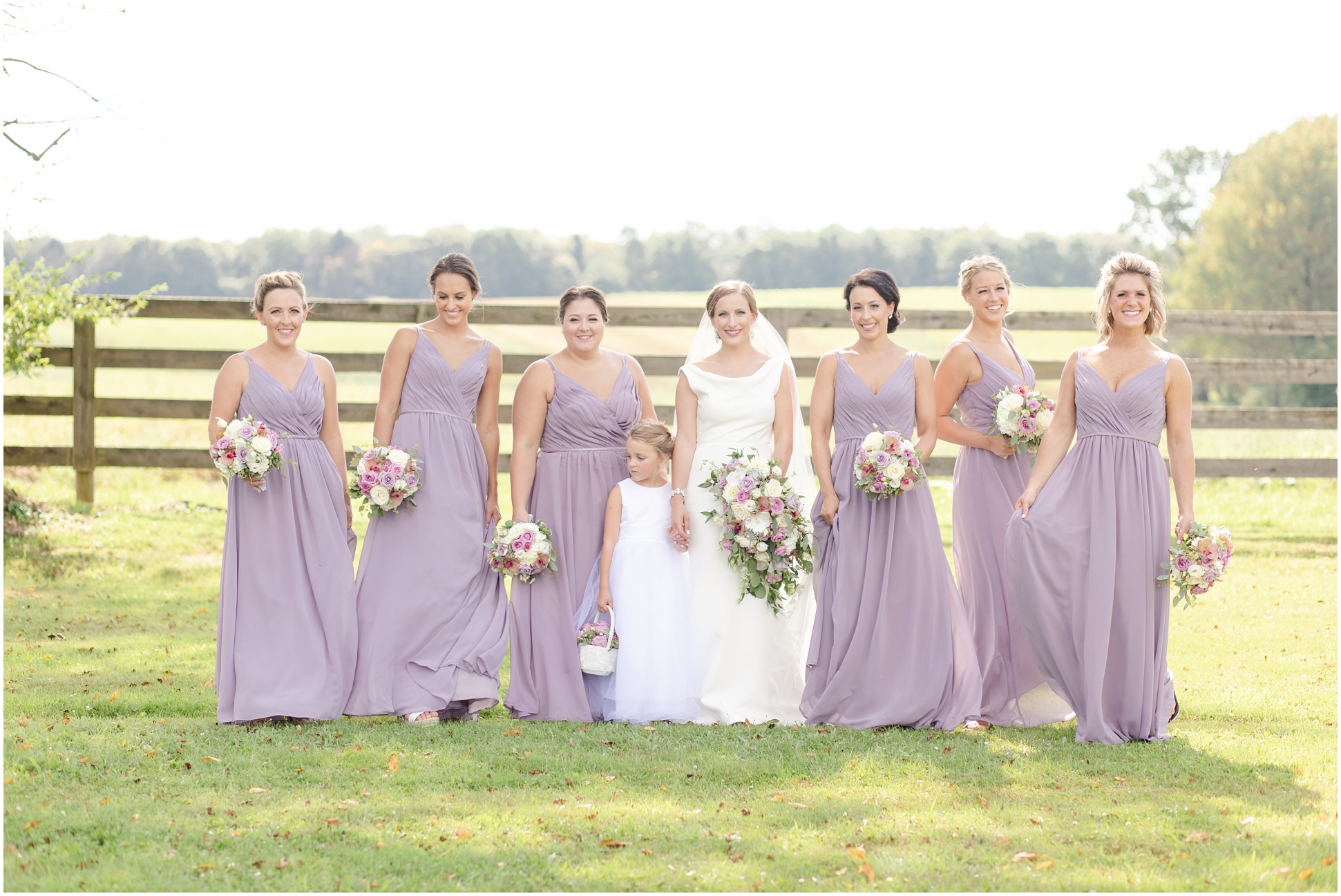 Bride and her bridal party wearing long purple dresses walking toward the camera