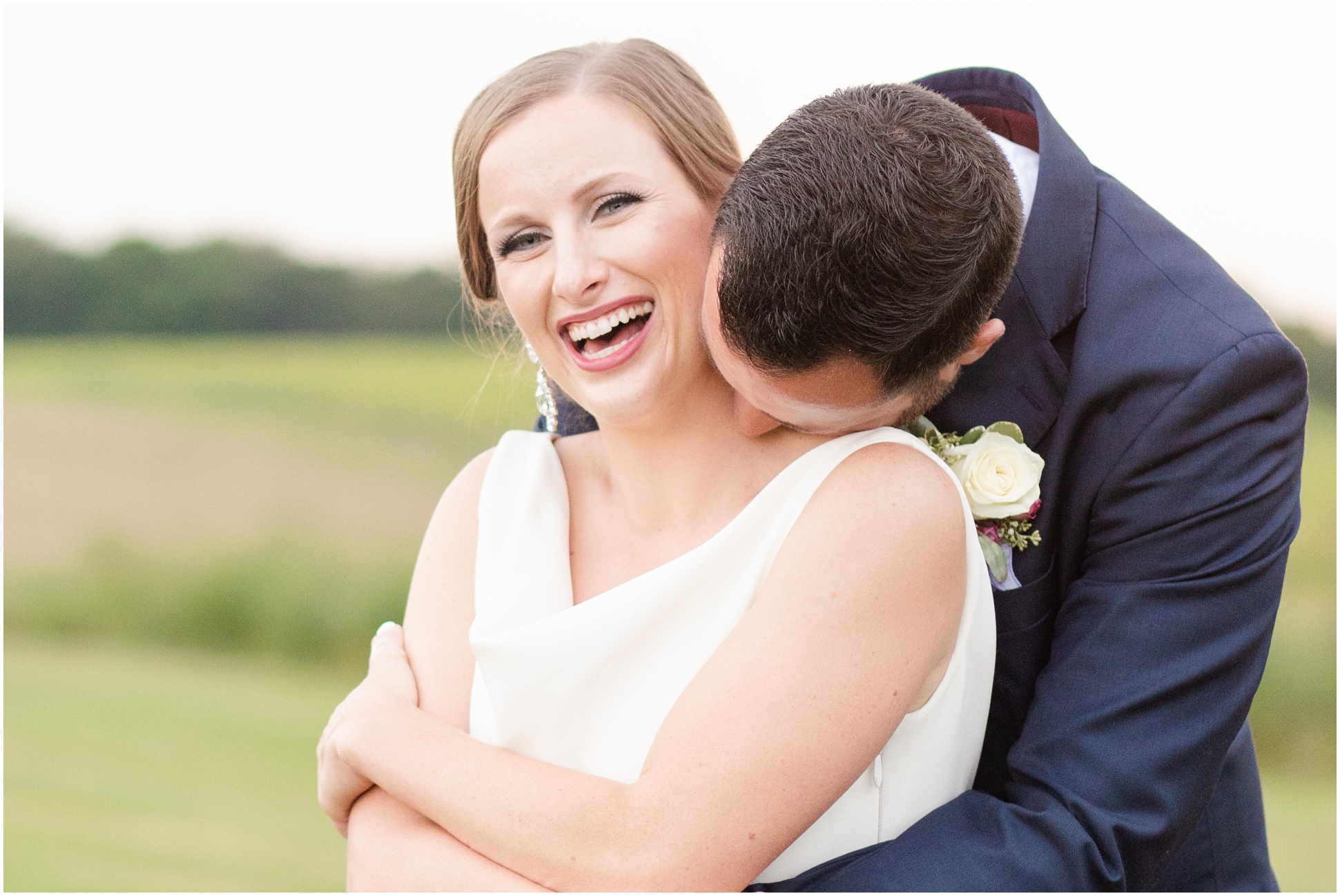 The bride giggling because the groom was tickling her neck with his lips