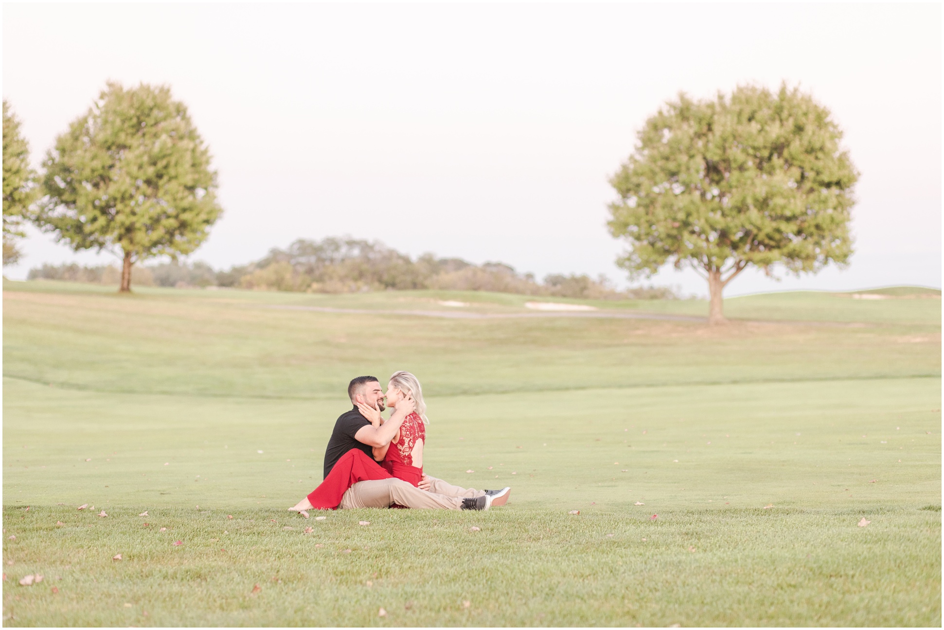 Far out shot of Landry and Bobby snuggling between two trees on the Gretystone Golf Course