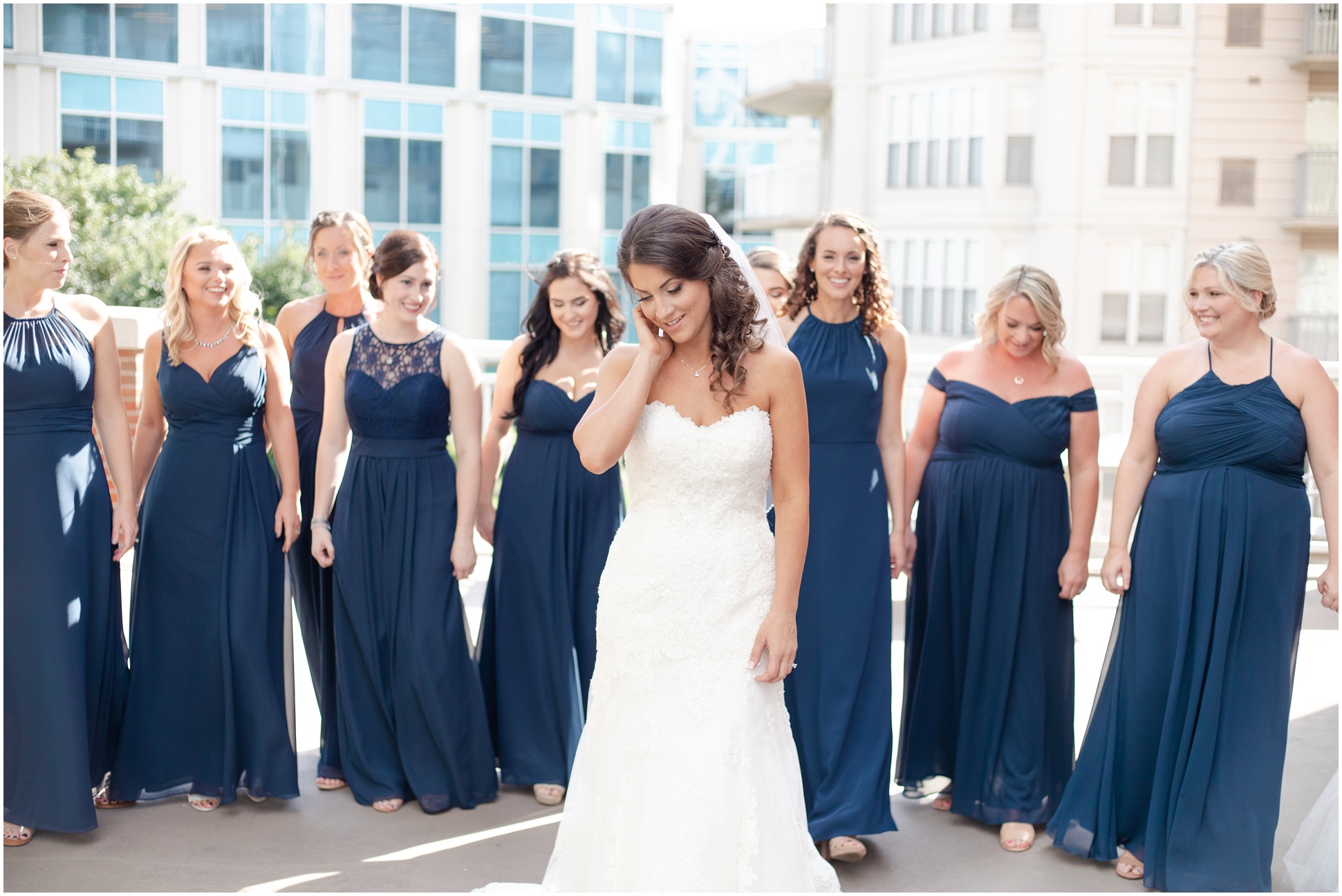 Bridesmaids and Bride walking on the patio of the hotel. Bridesmaids wearing long blue dresses