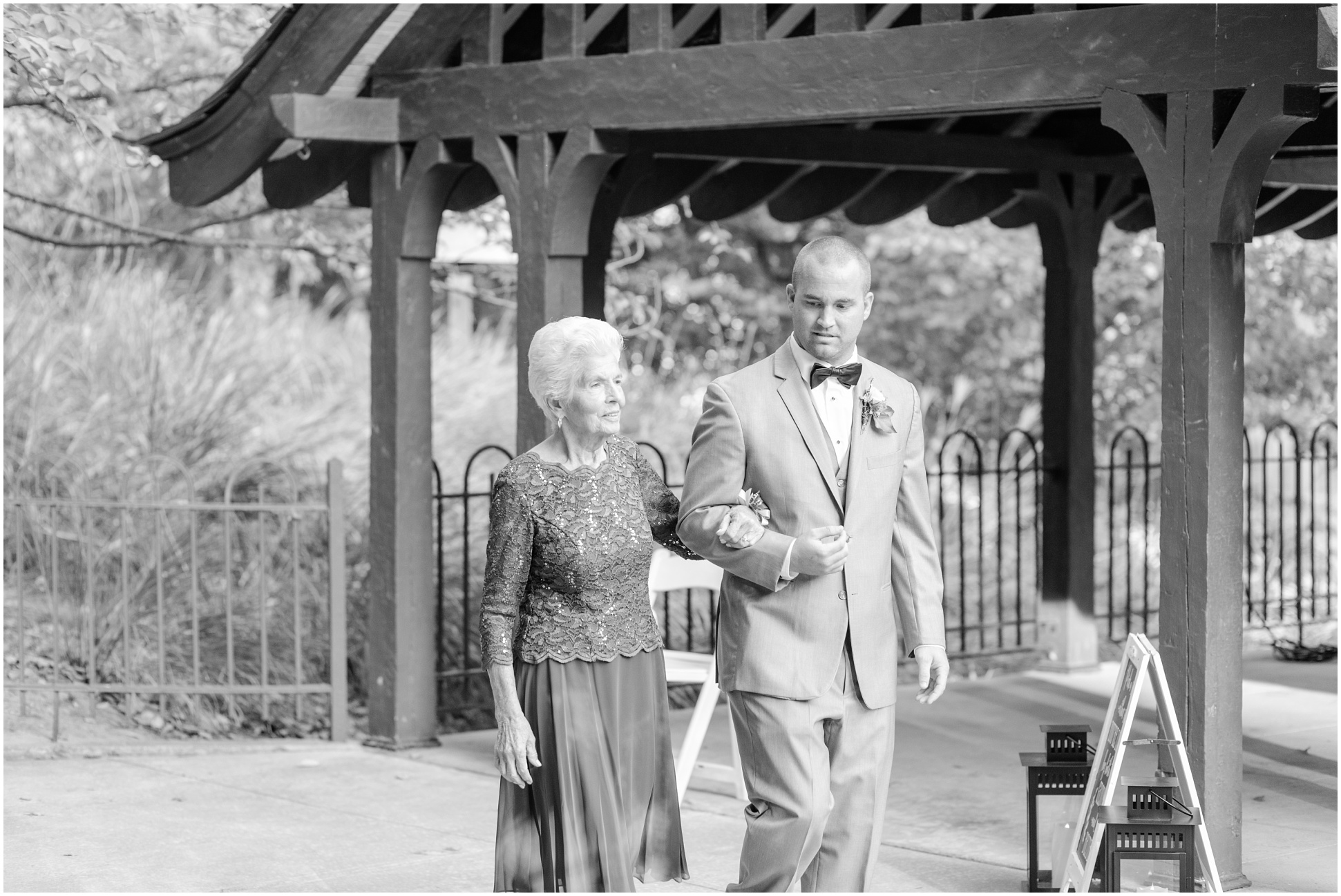 Groom escorting his grandmother to her seat.