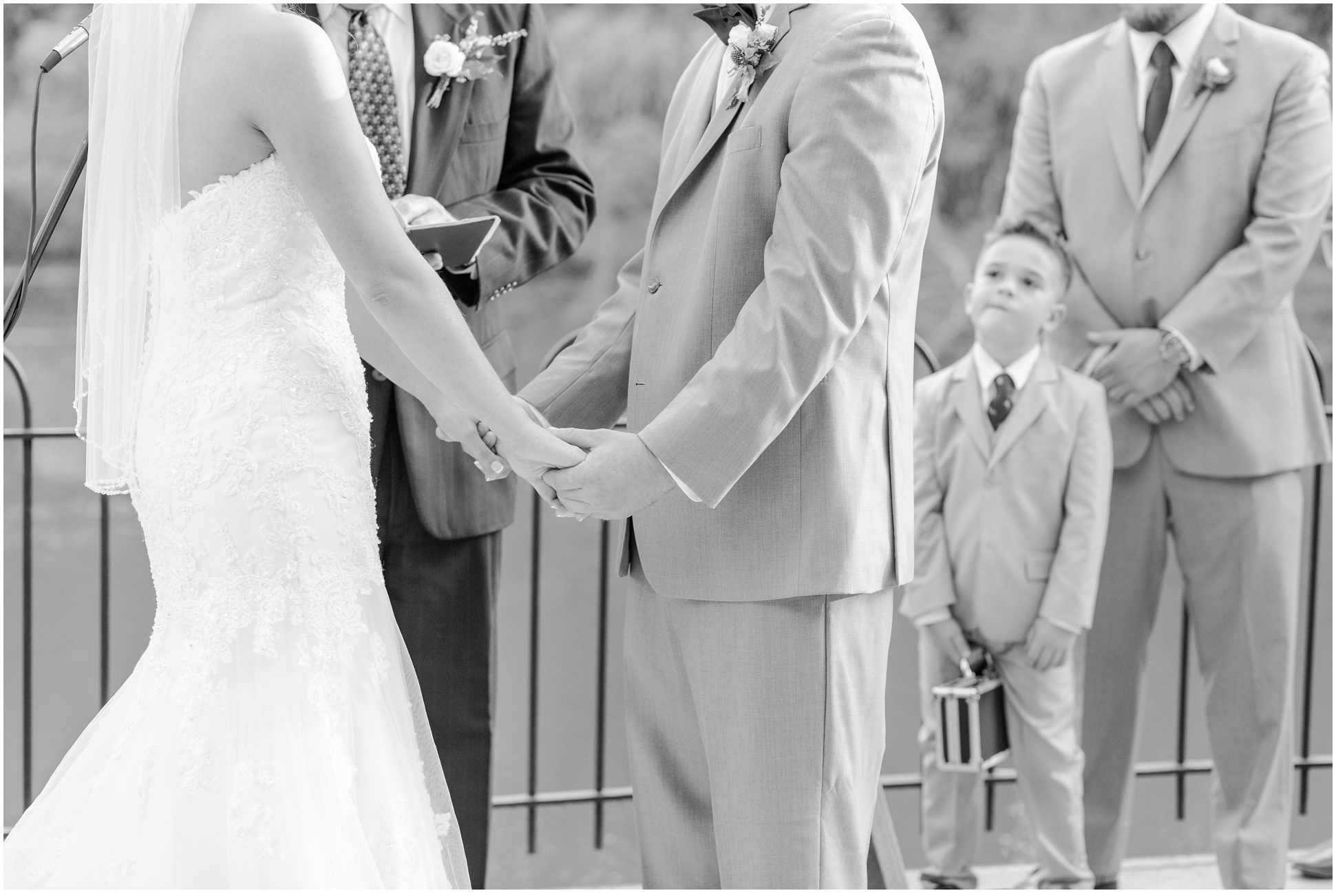 Black and white of bride and groom holding hands during their maryland zoo wedding ceremony