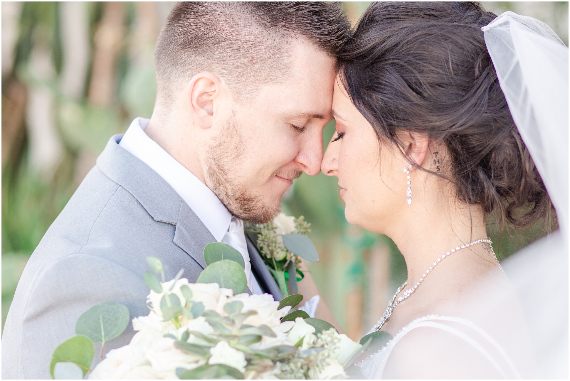 Bride and Groom touching foreheads with eyes closed while smiling
