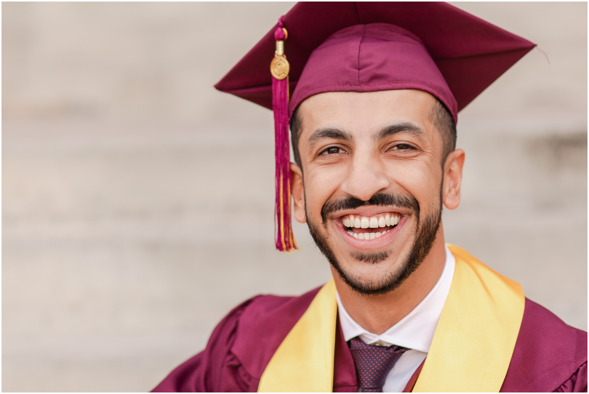 portrait of ASU graduate smiling at camera while sitting on stairs