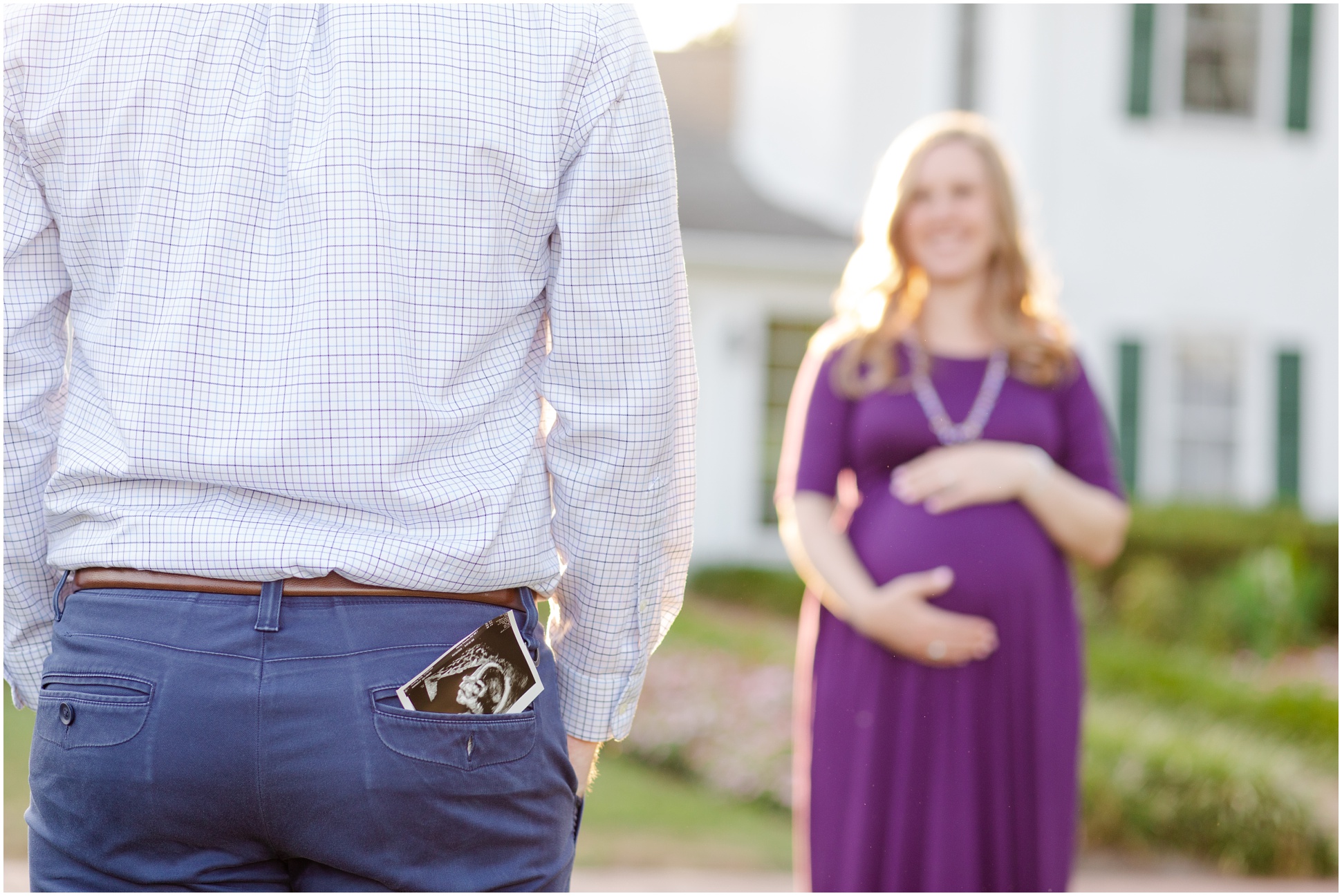 husband with sonogram in back pocket looking at expecting wife