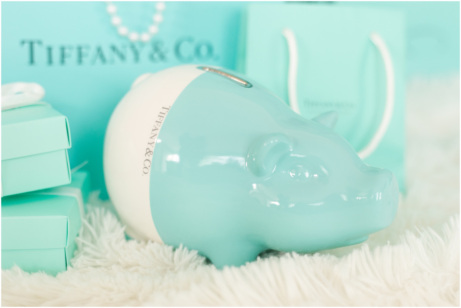 Tiffany & Co piggy bank surrounded by Tiffany & Co bags