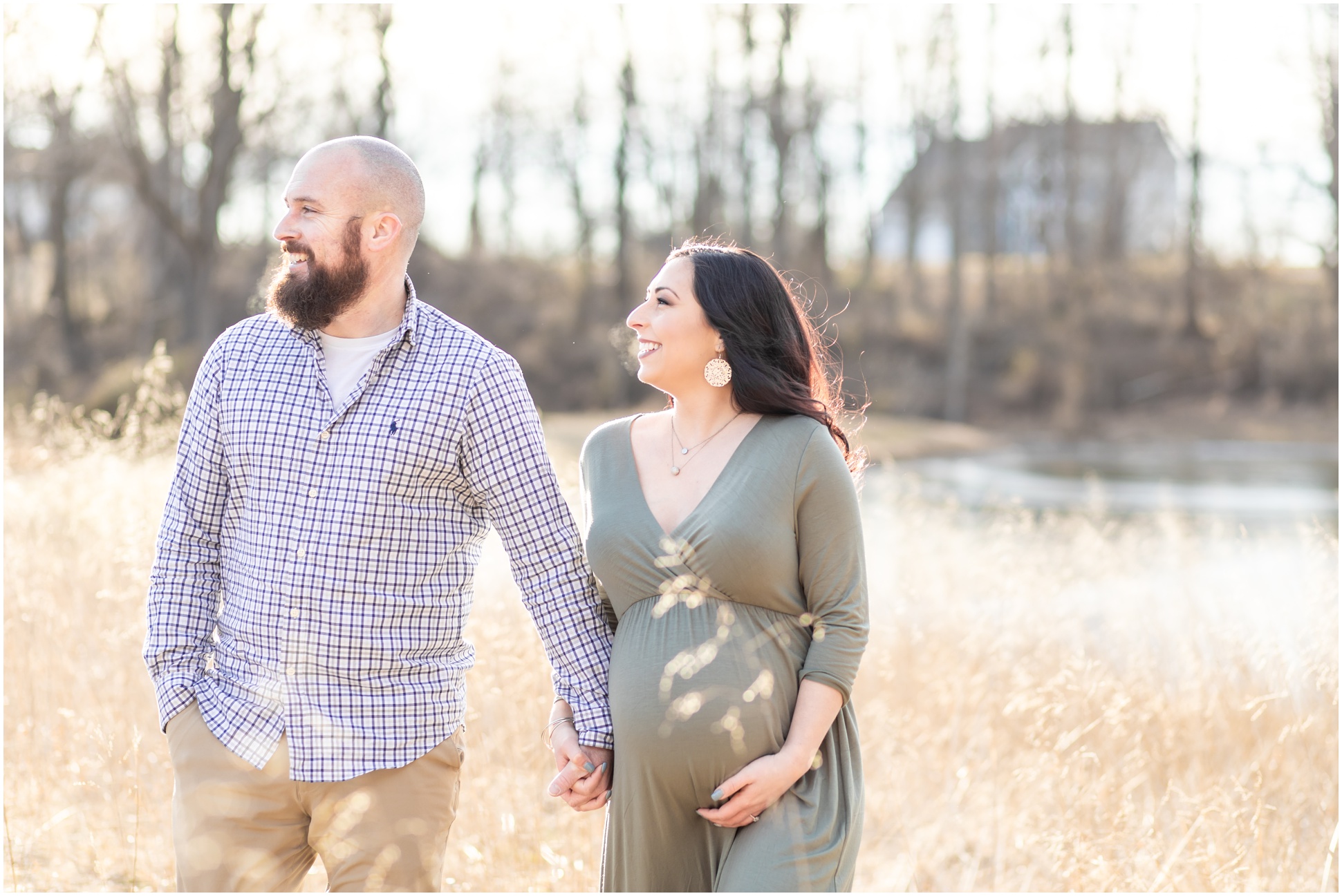 maternity session couple walking in wheat field