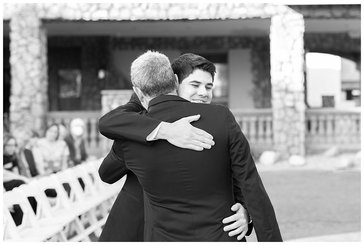 Black and white of groom hugging dad