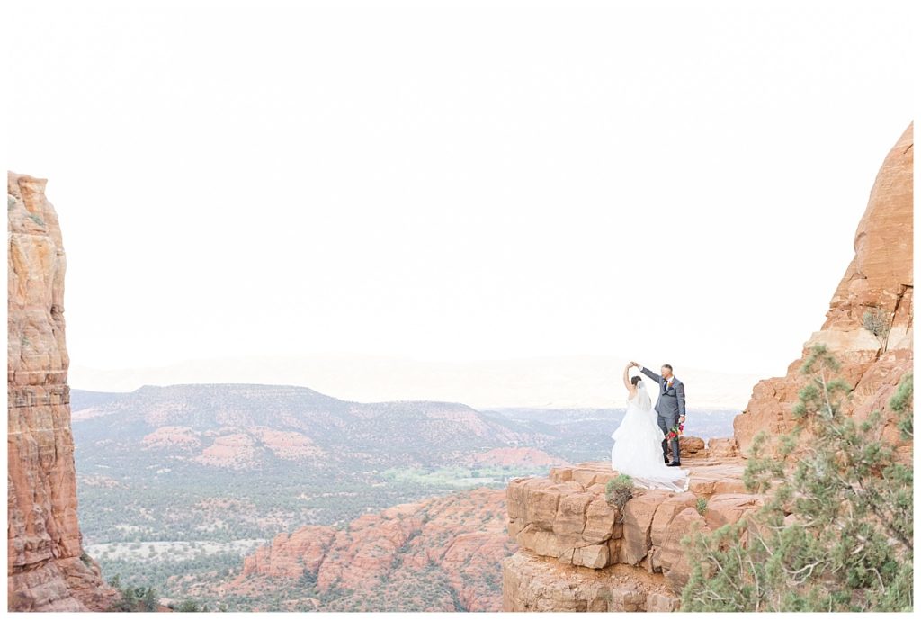 Bride and Groom twirling on Cathedral Rock at Sunrise.