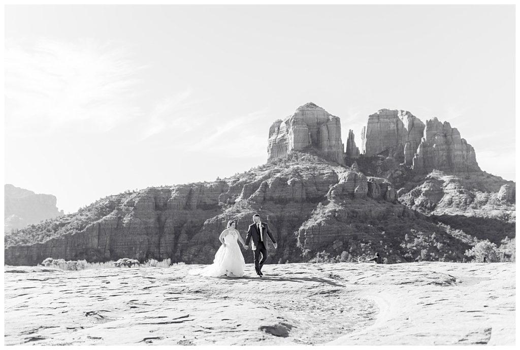 Black and white of bride and groom walking at Secret Slide Rock in Sedona Arizona