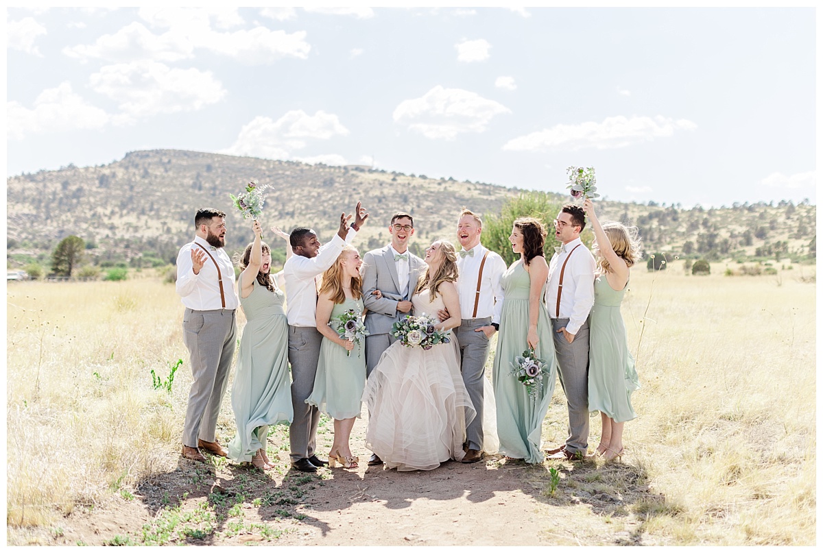 Full bridal party wearing sage green and gray