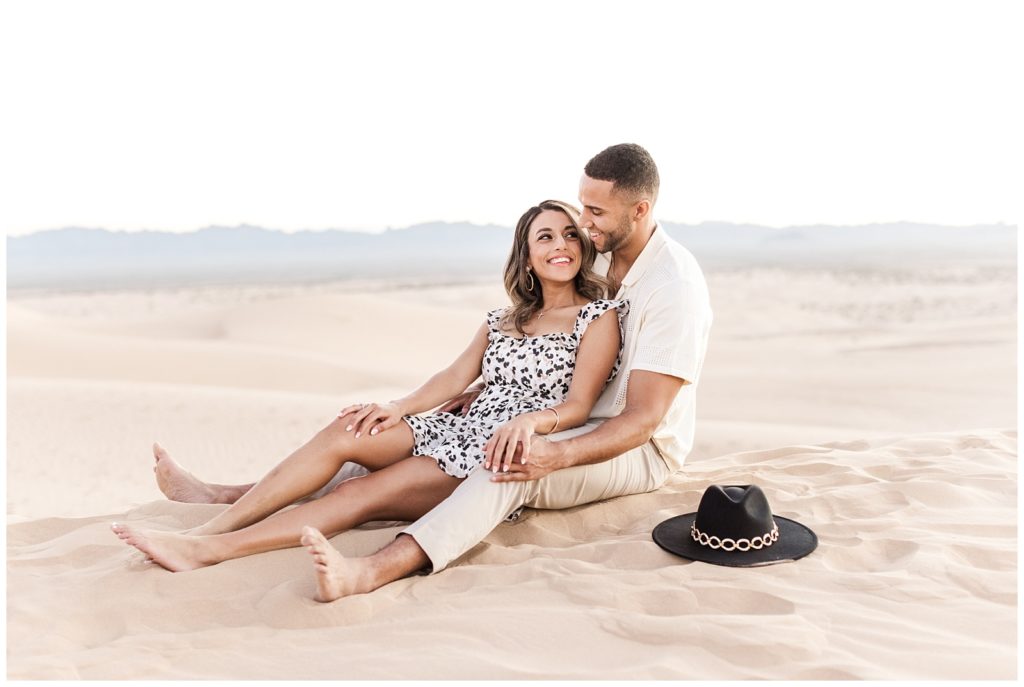 Mary and Jordan snuggling up on a sand dune for their engagement session.