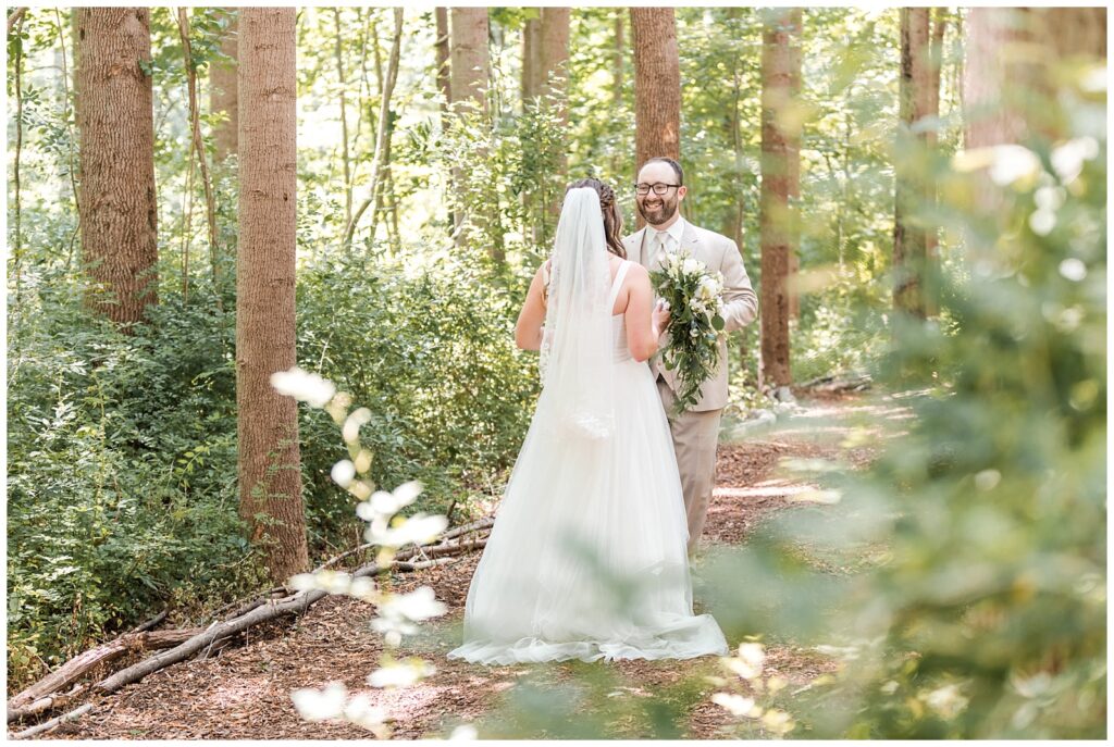 Bride and groom share a first look in the forest