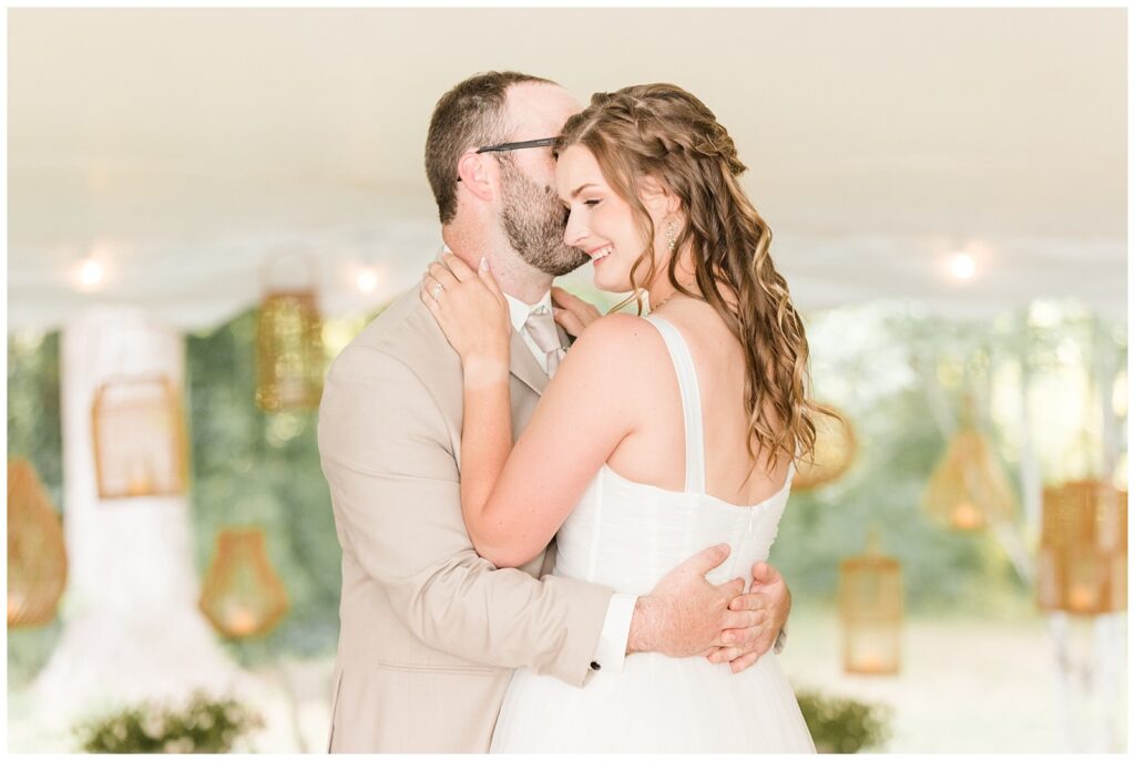 Bride and groom share their first dance under a lamplit tent