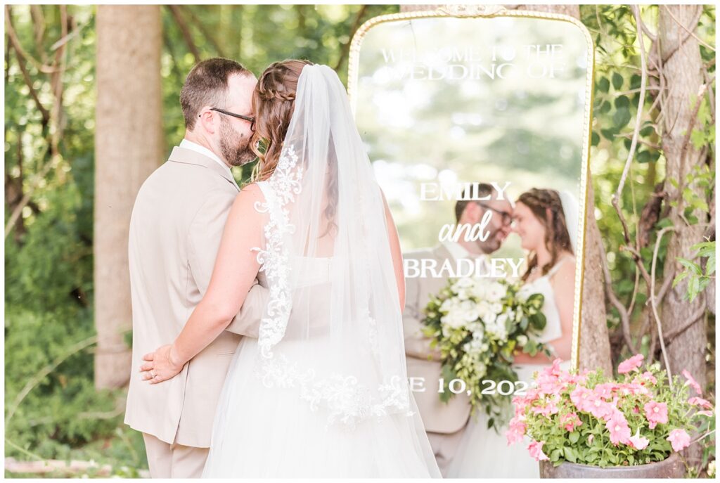 Bride and groom share a private moment in front of custom antique mirror