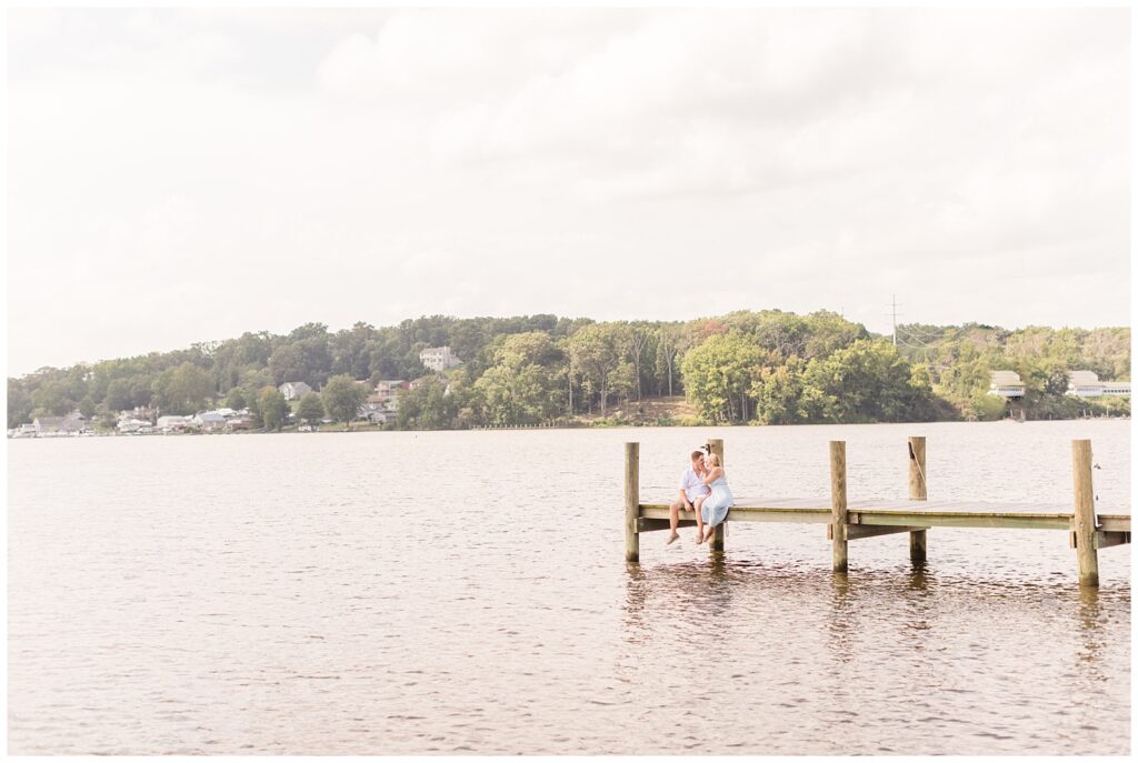 Couple kissing while sitting on a dock