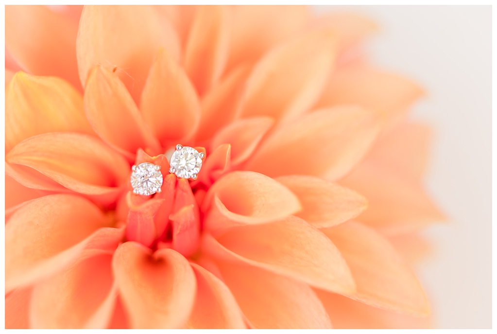 Detail shot of bride's earrings resting on the petals of a dahlia