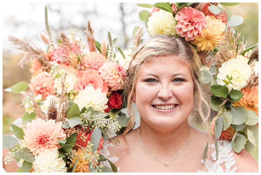 Bride's face surrounded by autumnal bridal bouquets